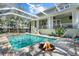 Stunning screened-in pool area with a spa, fire pit, and an outdoor seating, perfect for relaxation and entertainment at 4603 S Bartlett St, Tampa, FL 33611
