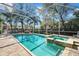 Enclosed lanai featuring a large pool, spa, brick paver deck, and tropical landscaping at 4603 S Bartlett St, Tampa, FL 33611