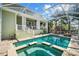 A beautiful pool area with spa, enclosed lanai, and a view of the backyard at 4603 S Bartlett St, Tampa, FL 33611