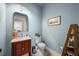Charming powder room featuring a decorative vanity, artwork, and blue walls at 4603 S Bartlett St, Tampa, FL 33611