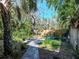 Expansive backyard featuring tropical landscaping, stone walkways, a charming bridge, and a serene atmosphere at 5029 29Th S Ave, Gulfport, FL 33707