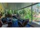 Comfortable screened porch with wicker furniture offering views of a lush backyard at 5029 29Th S Ave, Gulfport, FL 33707