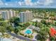 Aerial view of community featuring high-rise condos, a community pool, and lush landscaping at 5940 Pelican Bay S Plz # 1205, Gulfport, FL 33707