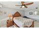 This cozy bedroom is complete with a wood bed frame, a ceiling fan, and serene wall art at 5940 Pelican Bay S Plz # 1205, Gulfport, FL 33707