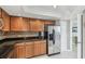 Well-lit kitchen with oak cabinets, black granite countertops, stainless steel appliances, and elegant tile flooring at 5940 Pelican Bay S Plz # 1205, Gulfport, FL 33707