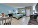 Bright bedroom features light blue walls, tile floor, queen bed, beach decor and a window overlooking a green field at 611 Destiny Dr # 304, Ruskin, FL 33570