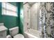 A well-lit bathroom with a shower-tub combo featuring marble tile and a floral shower curtain at 6907 N 12Th St, Tampa, FL 33604