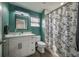 Bathroom features a vessel sink on a white vanity, floral shower curtain, and dark green walls at 6907 N 12Th St, Tampa, FL 33604