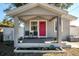 Inviting front porch with seating and vibrant pink door, offering a cozy curb appeal at 6907 N 12Th St, Tampa, FL 33604
