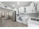 Well-lit kitchen with stainless steel appliances, white cabinets, open to a dining area with a table and chairs at 6907 N 12Th St, Tampa, FL 33604