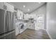 Bright kitchen featuring white cabinetry, stainless steel appliances, and hardwood floors with a door leading to the outside at 6907 N 12Th St, Tampa, FL 33604