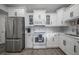 Modern kitchen featuring a stainless steel refrigerator, white cabinets, and gray backsplash at 6907 N 12Th St, Tampa, FL 33604