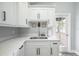 A well-lit kitchen with a door leading to the deck outside, featuring white cabinets and countertop at 6907 N 12Th St, Tampa, FL 33604