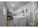 Functional laundry room with modern washer and dryer, utility sink, and convenient shelving at 6907 N 12Th St, Tampa, FL 33604