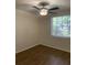 Cozy bedroom featuring hardwood floors, a lighted ceiling fan, and a large window overlooking the yard at 7111 N 53Rd St, Tampa, FL 33617
