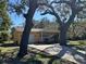 Quaint yellow home featuring an attached garage, front porch, and large shade trees on the property at 7111 N 53Rd St, Tampa, FL 33617