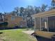 Backyard view of a yellow two-story home with a basketball hoop and a screened-in porch at 7111 N 53Rd St, Tampa, FL 33617