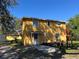 Yellow two-story home with front porch, showing landscaping at 7111 N 53Rd St, Tampa, FL 33617