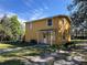 Exterior view of a two-story yellow home with a covered front porch and a well-maintained lawn at 7111 N 53Rd St, Tampa, FL 33617