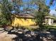 Yellow home featuring an enclosed lanai, mature trees, and manicured landscaping in a tranquil setting at 7111 N 53Rd St, Tampa, FL 33617