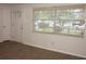 Bright living room with hardwood floors, white trim, a large window, and a new front door at 7111 N 53Rd St, Tampa, FL 33617