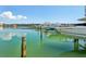 Community boat slips sit on calm waters on a bright day with light clouds at 7400 Sun Island Drive S # 712, South Pasadena, FL 33707