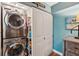 Modern laundry room with stacked washer and dryer and white sliding door at 7400 Sun Island Drive S # 712, South Pasadena, FL 33707