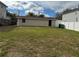 View of the backyard, showing a detached building with a dark door at 7909 N Packwood Ave, Tampa, FL 33604
