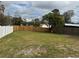 A fenced backyard with a combination of wooden and white fencing at 7909 N Packwood Ave, Tampa, FL 33604