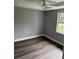 A bedroom with gray vinyl floors, neutral walls, white trim, a window, and a ceiling fan at 7909 N Packwood Ave, Tampa, FL 33604