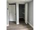 A bedroom closet with shelves, an open door, gray walls, and gray vinyl floors at 7909 N Packwood Ave, Tampa, FL 33604