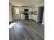 Well-lit kitchen with gray vinyl floors, stainless steel appliances, and white cabinets at 7909 N Packwood Ave, Tampa, FL 33604