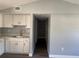 A kitchen with gray vinyl floors, white cabinets, neutral walls, and stainless steel sink at 7909 N Packwood Ave, Tampa, FL 33604