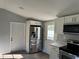A kitchen with stainless steel refrigerator, gray vinyl flooring, and white cabinets at 7909 N Packwood Ave, Tampa, FL 33604