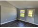 A well-lit living room with gray vinyl floors, neutral walls, and an exterior door at 7909 N Packwood Ave, Tampa, FL 33604