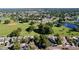 Expansive aerial view showcasing a neighborhood with a park, lake, and lush landscape at 10408 Rosemount Dr, Tampa, FL 33624