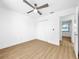 White bedroom featuring modern ceiling fan, wood flooring and door to other rooms at 10408 Rosemount Dr, Tampa, FL 33624