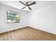 Bright, minimalist bedroom with modern ceiling fan and window overlooking trees at 10408 Rosemount Dr, Tampa, FL 33624