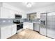 Modern kitchen featuring stainless steel appliances, white cabinets, and a light blue tile backsplash at 10408 Rosemount Dr, Tampa, FL 33624