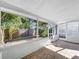 Enclosed sunroom featuring tile flooring, large windows, and backyard views at 10408 Rosemount Dr, Tampa, FL 33624