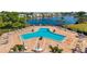 Aerial view of the community pool and amenity center with lounge chairs and patio furniture near the lake at 108 Pompano Se Dr # A, St Petersburg, FL 33705