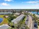 Aerial view of the condominiums showing lush landscaping, lake, and ample parking at 108 Pompano Se Dr # A, St Petersburg, FL 33705