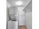 Small laundry closet featuring stacked washer and dryer with wood-look floor at 108 Pompano Se Dr # A, St Petersburg, FL 33705