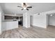 Open-concept living area with new floors, ceiling fan, and a kitchen view at 108 Pompano Se Dr # A, St Petersburg, FL 33705