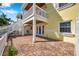 Brick patio with stairs to an upper deck and views of the house's yellow exterior at 108 Pompano Se Dr # A, St Petersburg, FL 33705