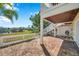 Brick patio with stairs to an upper deck, overlooking a grassy area and lake at 108 Pompano Se Dr # A, St Petersburg, FL 33705