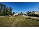 Expansive front yard of a single-story home, long driveway, mature trees, and well-maintained landscaping at 1113 Carlton Rd, Tarpon Springs, FL 34689