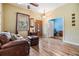 Cozy living room featuring hardwood floors, a comfortable leather sofa, and a decorative wooden front door at 12508 Balm Riverview Rd, Riverview, FL 33579