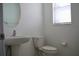 Bathroom featuring pedestal sink, toilet, mirror, and window with blinds at 14352 Editors Note St, Ruskin, FL 33573