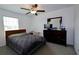 Bedroom with window, ceiling fan, carpet, and a dark wood dresser at 14352 Editors Note St, Ruskin, FL 33573